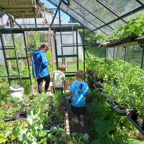adult and 2 children in a greenhouse