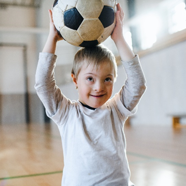 Photo of a child balancing a football on their head
