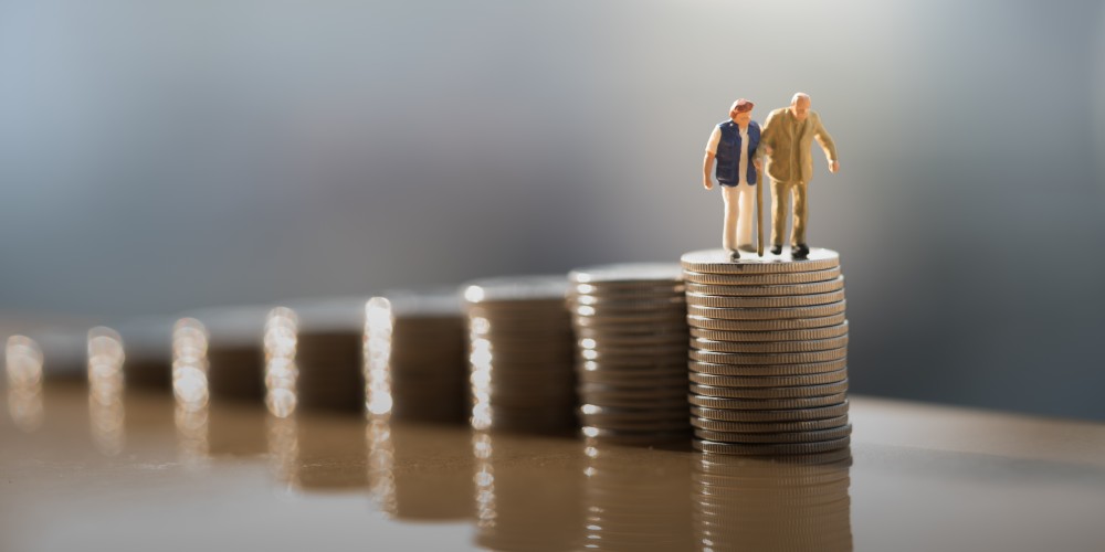 Figures of man and woman walking on stacks of coins