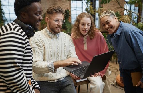 A group of people looking at something on a laptop