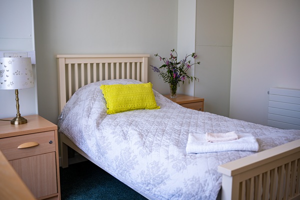 Care home bed with yellow pillow