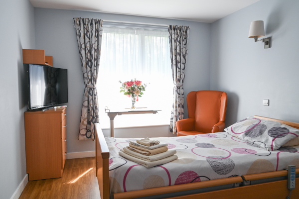 A bedroom with TV and side table