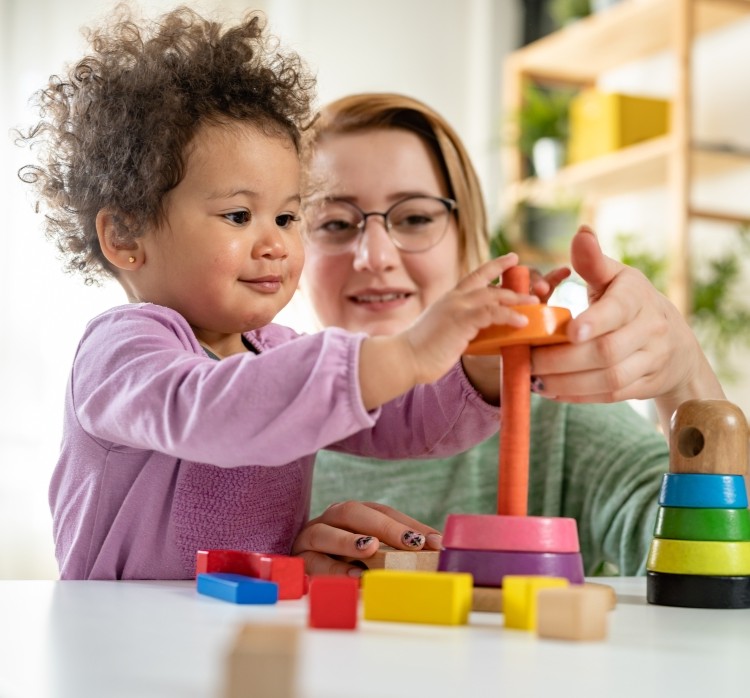 A woman and a child playing with a building toy