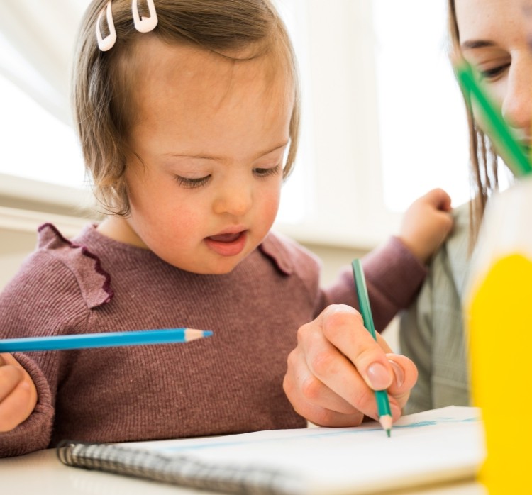 Young girl with a coloured pencil and a book