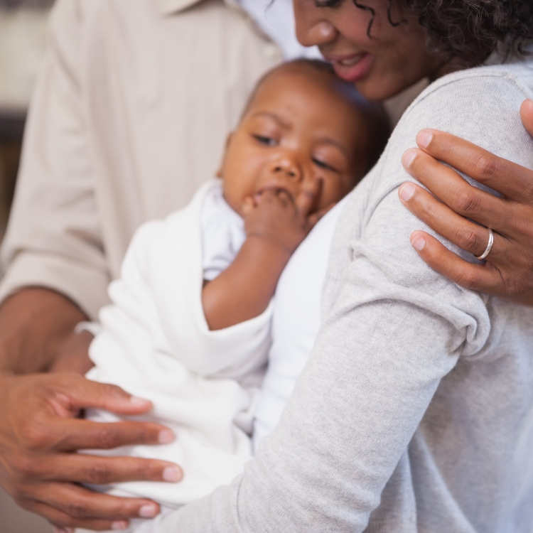Parents holding their baby close to them