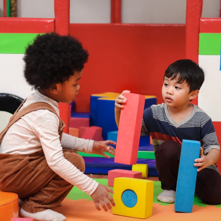 Two young children playing with colourful toys