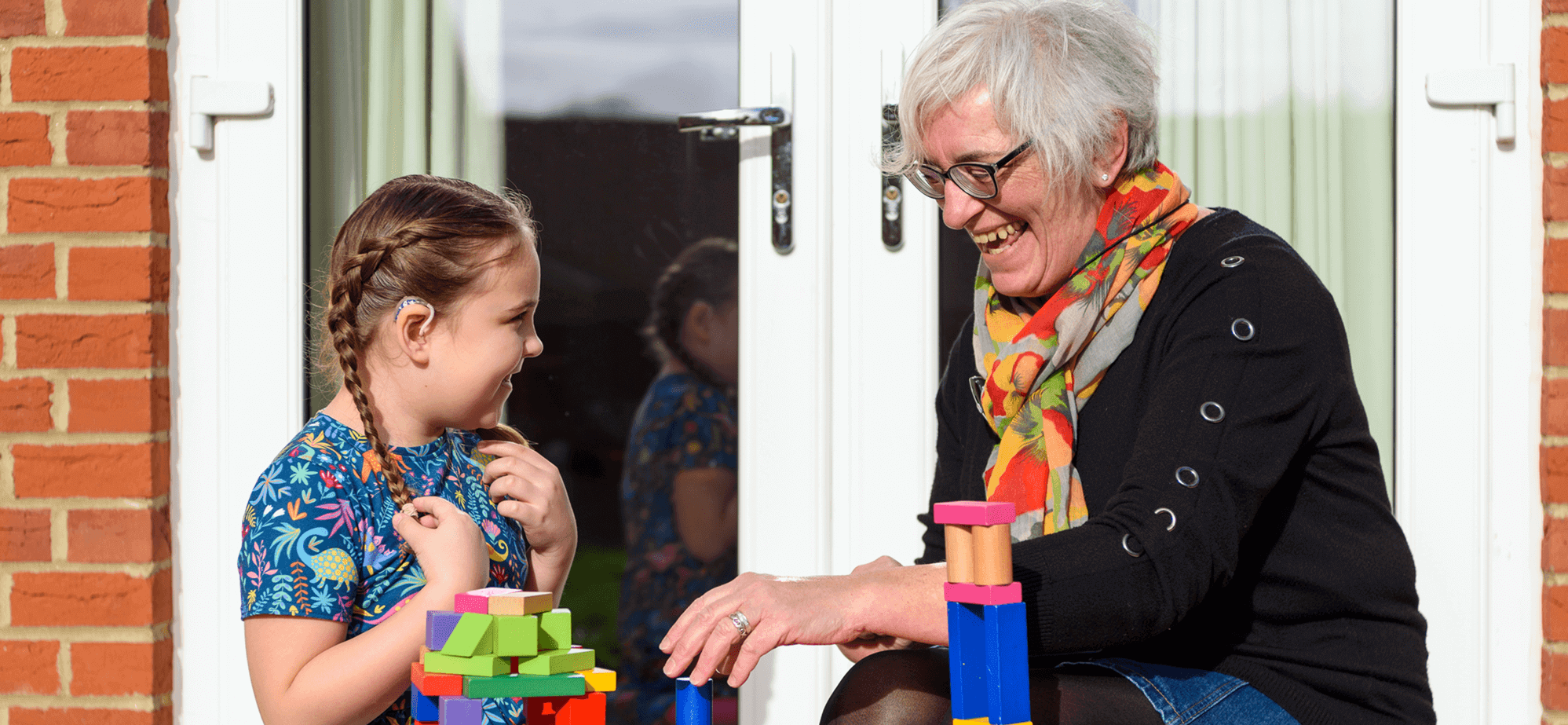A woman and a child outdoors playing.