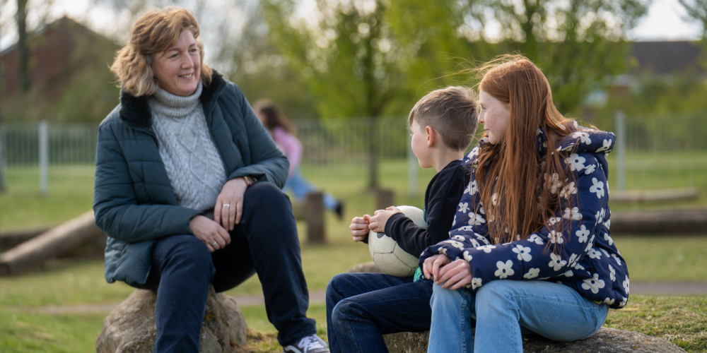 A woman with two children at the park