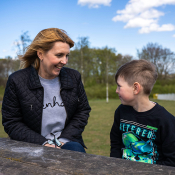 A woman and a young boy sat at a picnic bench