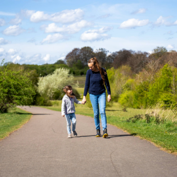 A woman and a young girl walking through the countryside