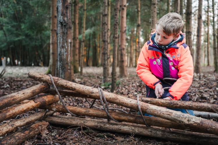 Boy tying logs together
