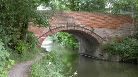 Food path alongside the canal heading towards a red brick bridge