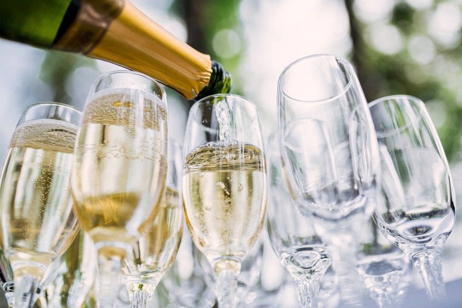 Close up shot of champagne being poured into a group of champagne glasses