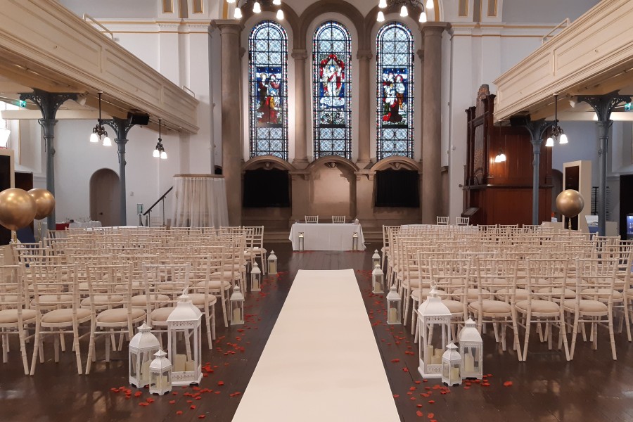 Wedding ceremony at The Chapel with petals down the aisle