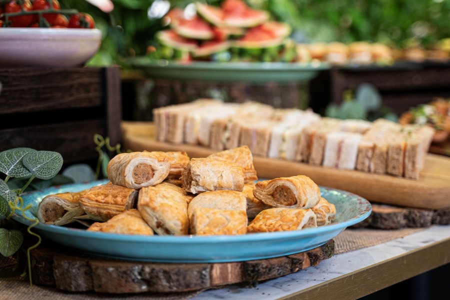 A selection of food including sausage rolls and sandwiches