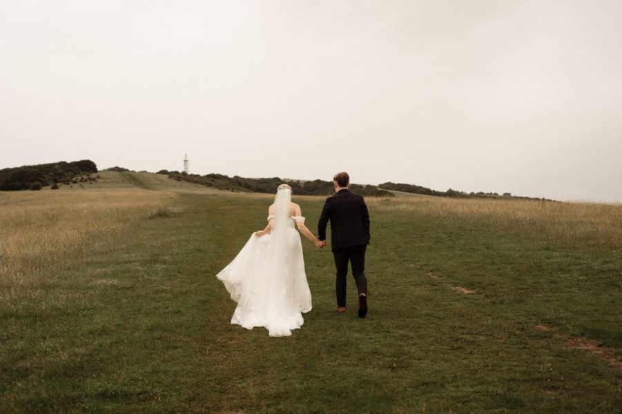 Bride and Groom walking along the field