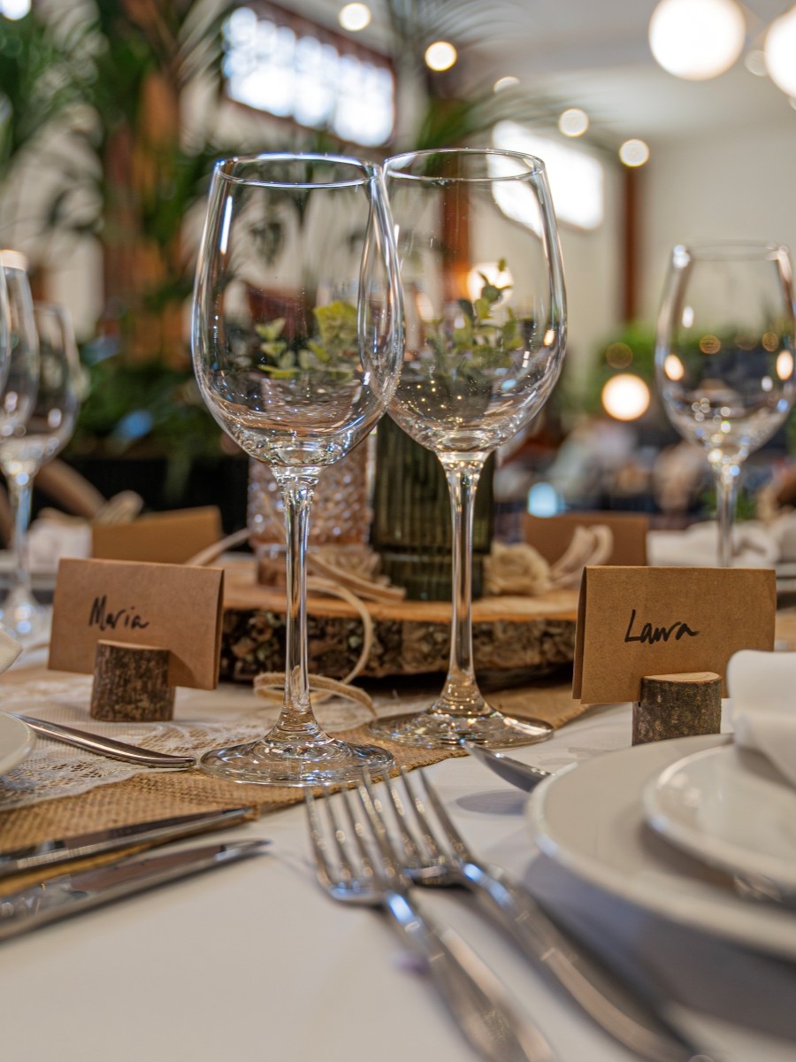 Table dressed for a wedding with while linen, silver cutlery and floral arrangements