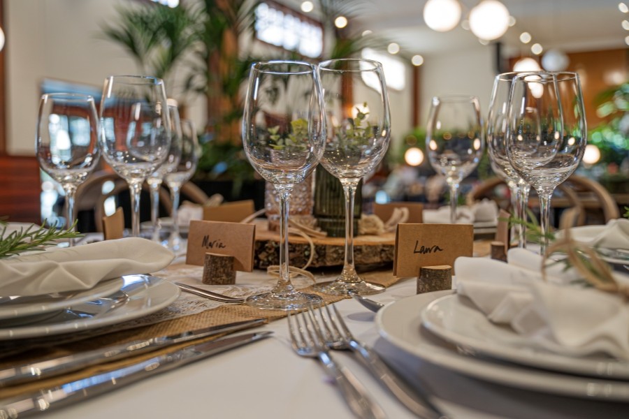 Table dressed for a wedding with while linen, silver cutlery and floral arrangements