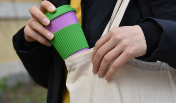 person holding a reusable coffee cup