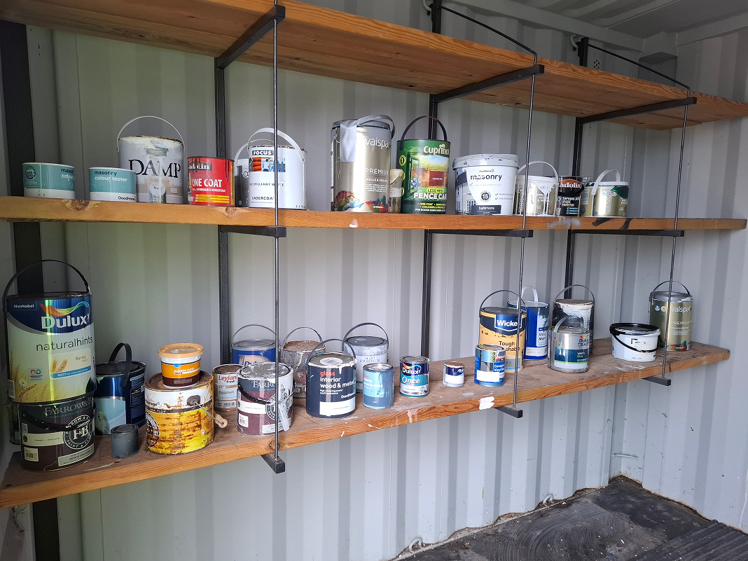 Photograph of cans of paint on a shelf
