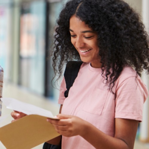 image shows girl opening exam results letter