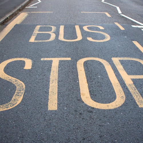 bus stop sign painted on roadway