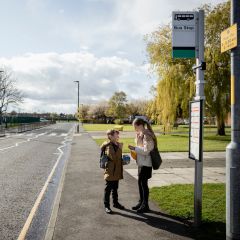 Two children stood at a bus stop