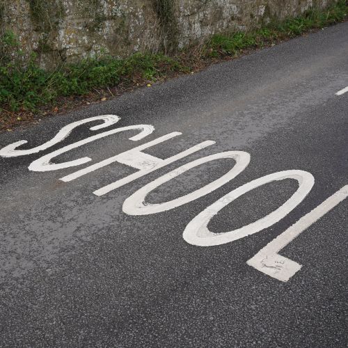 Road marking that reads 'school'