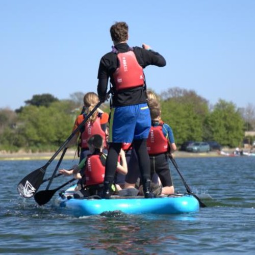 instructor with children paddleboarding