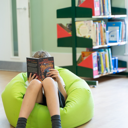 Child sat on beanbag reading a book