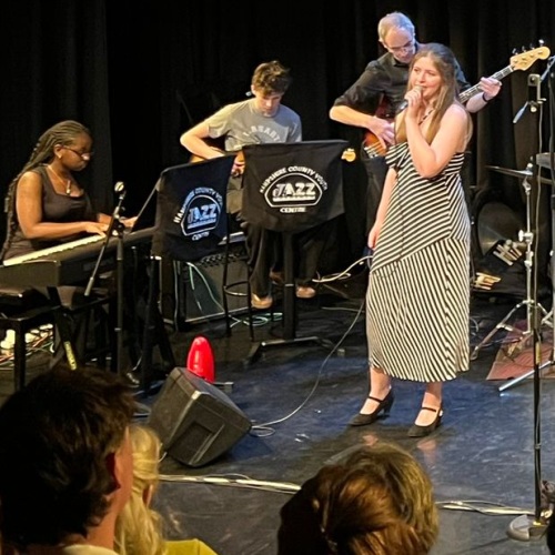 image shows a jazz band with young female vocalist