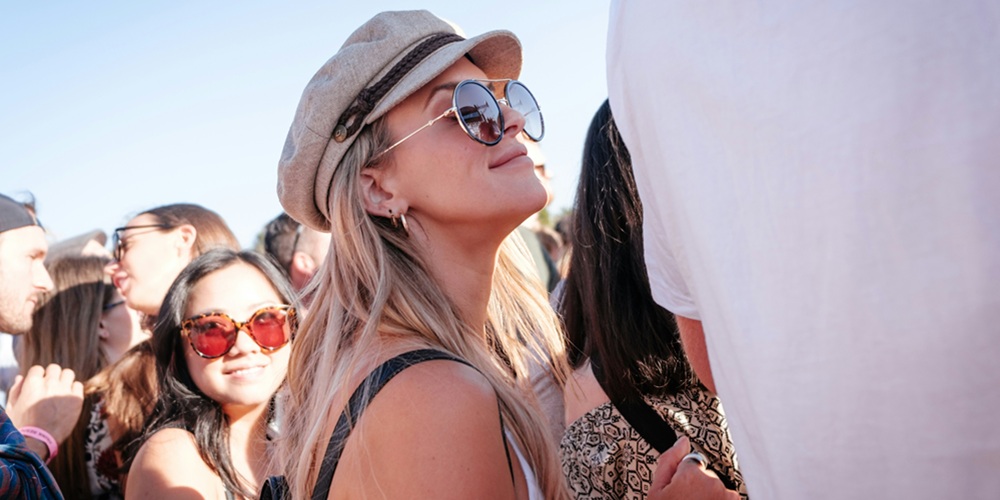 A girl at a music festival wearing sunglasses