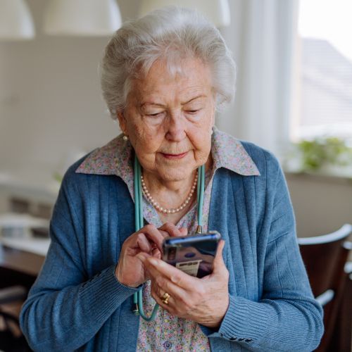 older woman using mobile phone at home