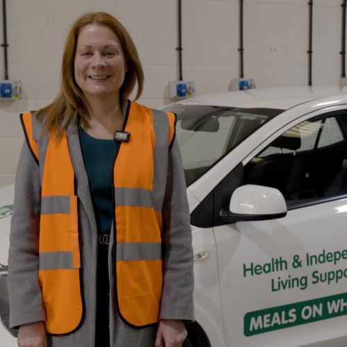 Councillor Zoe Huggins standing next to a white meals on wheels delivery care