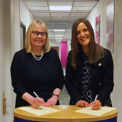 Image of Sarah Greer and Julie Milburn signing document