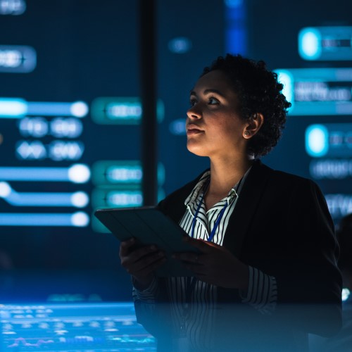 Woman surrounded by large screens of technical data