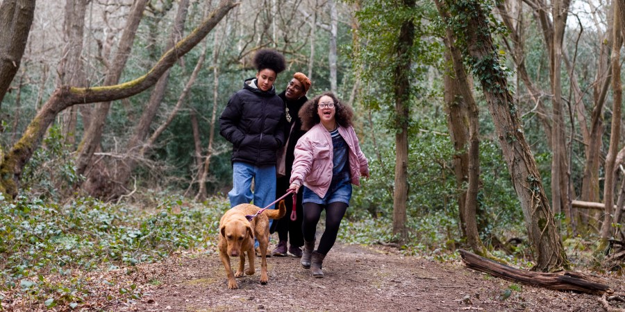 Family and their dog walking through the woods