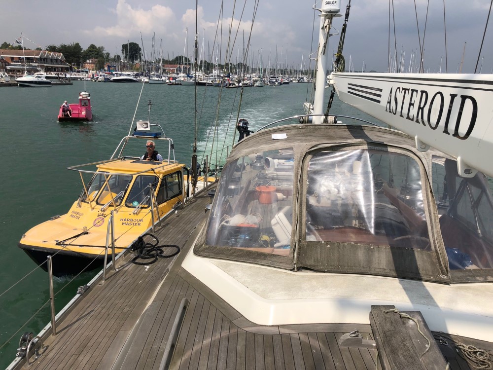 Yacht on tow by harbour patrol