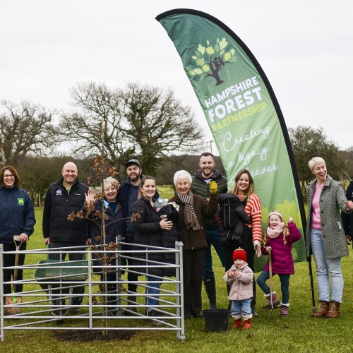 Group of people with a newly planted tree