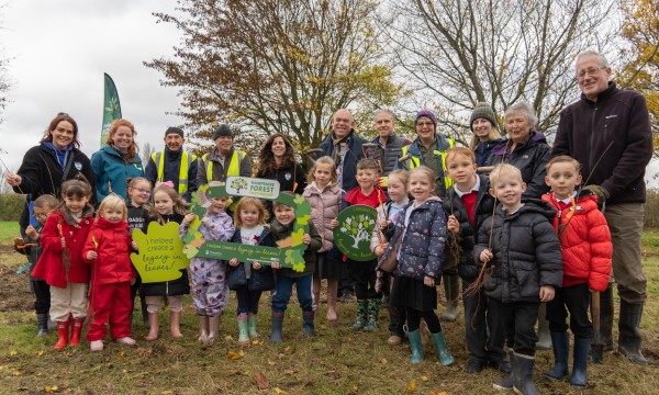 Group of adults and children at a tree planting event
