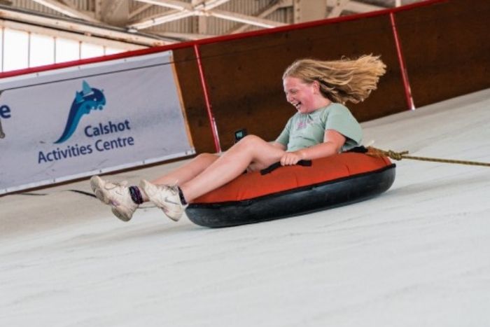 Girl travelling down an indoors slope on a ringo