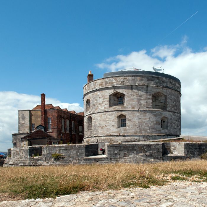 A circular stone castle standing in the sun.