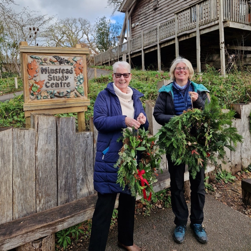 Participants of a wreath-making course holding their festive wreaths