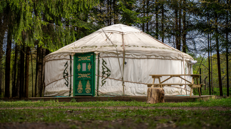 A white yurt with a green door