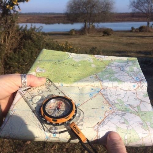 Someone holding a map and compass