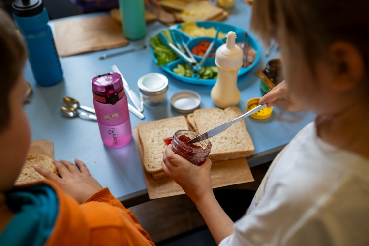 Children sitting at a table and making sandwiches