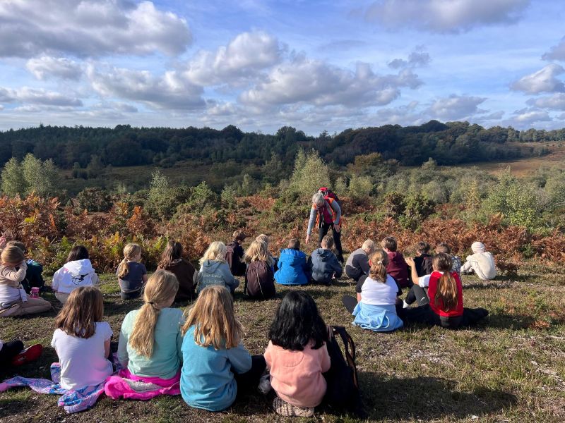 Group of children sitting on the ground of the New Forest open heathland