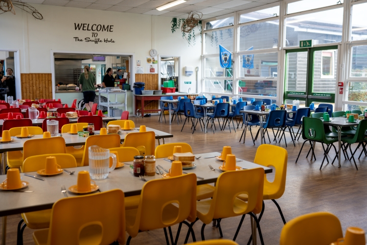 The catering hall at Stubbington with tables laid with colourful crockery and matching chairs