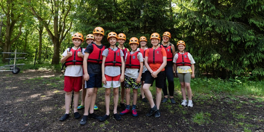 Group of children in hard hats and buoyancy aids