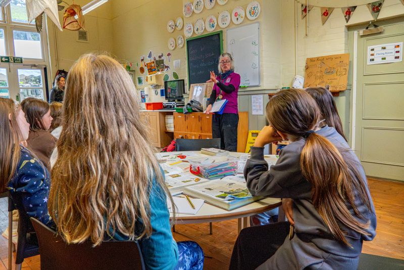 Children in a classroom listening to a teacher